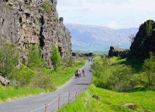 Fólk gengur upp þjónustuðan stíg Almannagjá á sumardegi