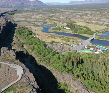 Loftmynd af þinghelginni frá lýðveldishátíðinni 2024. Fólksfjöldi, hátíðartjöld og Þingvallakirkja 