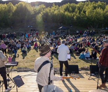 Reiðmenn vindanna fyrir framan hóp fólks. Birkiskógur í bakgrunni