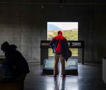 Maður stendur á sýningarliðinum "flekahreyfingar" á sýningunni Hjarta lands og þjóðar. Þar eru flekaskilin útskýrð.