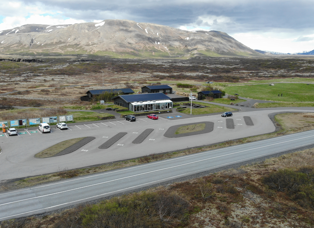 Service centre at Thingvellir by Nyrdri-Leirar. Near-empty parking lot. Campsite behind and Ármannsfell mountain in the background