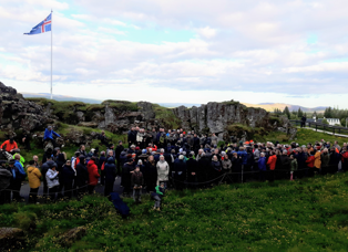 Margmenni við Lögberg í Almannagjá. Íslenski fáninn blaktir