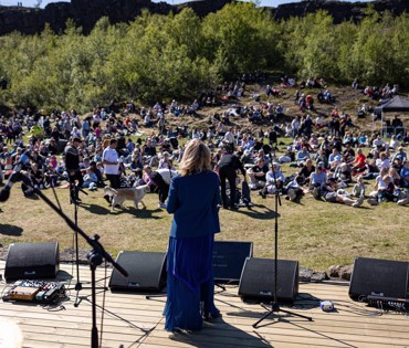 Hópur fólks hlustar á næsta flytjand vera kynntan á tónleikum