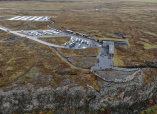 Aerial view of the visitor center at hakið. Parking lots are full and lots of people on the observation deck